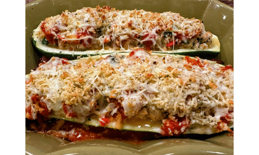 zucchini boats stuffed with chicken sausage, veggies, and cheese baked until golden brown in a casserole dish