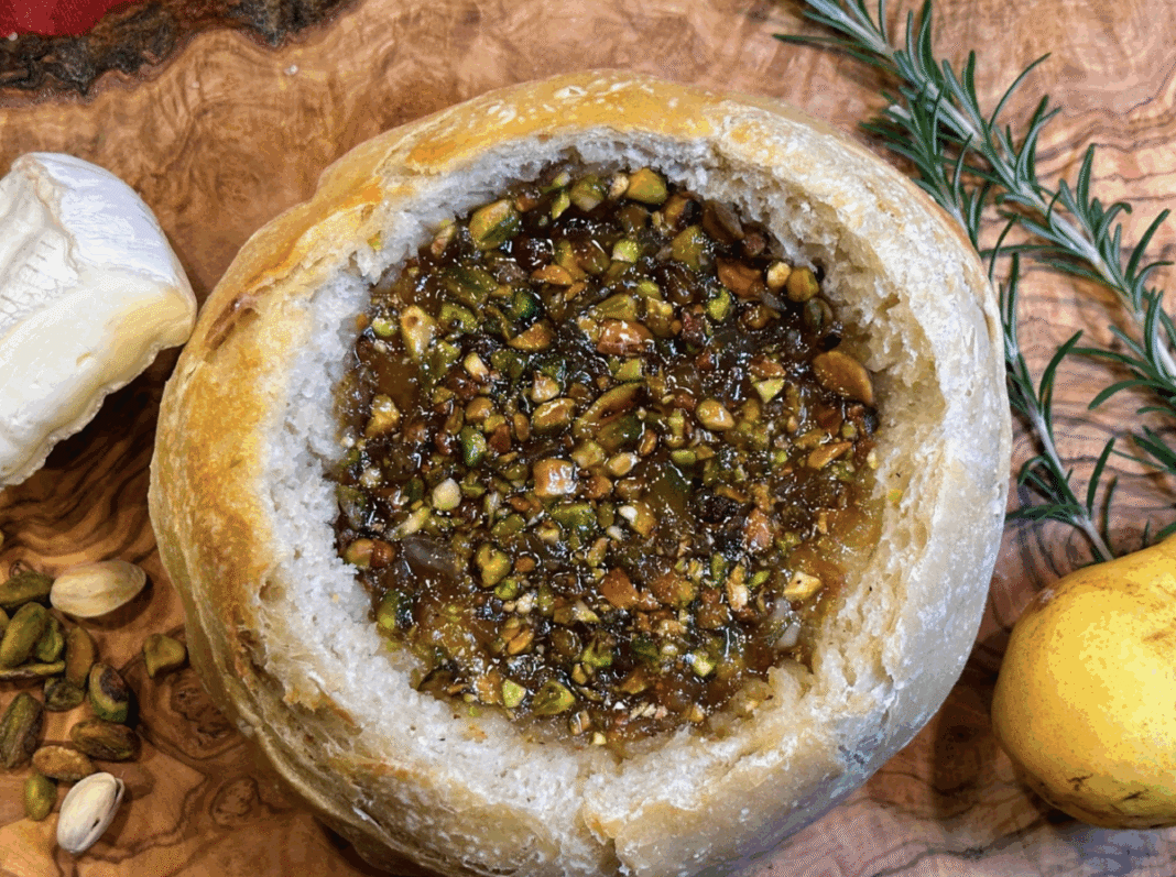 Pistachio Pear and Brie Stuffed Sourdough on a wooden board with fresh rosemary